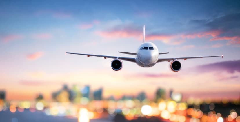 Airplane flying at twilight over city