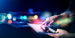 Hand touching tablet on abstract data background.