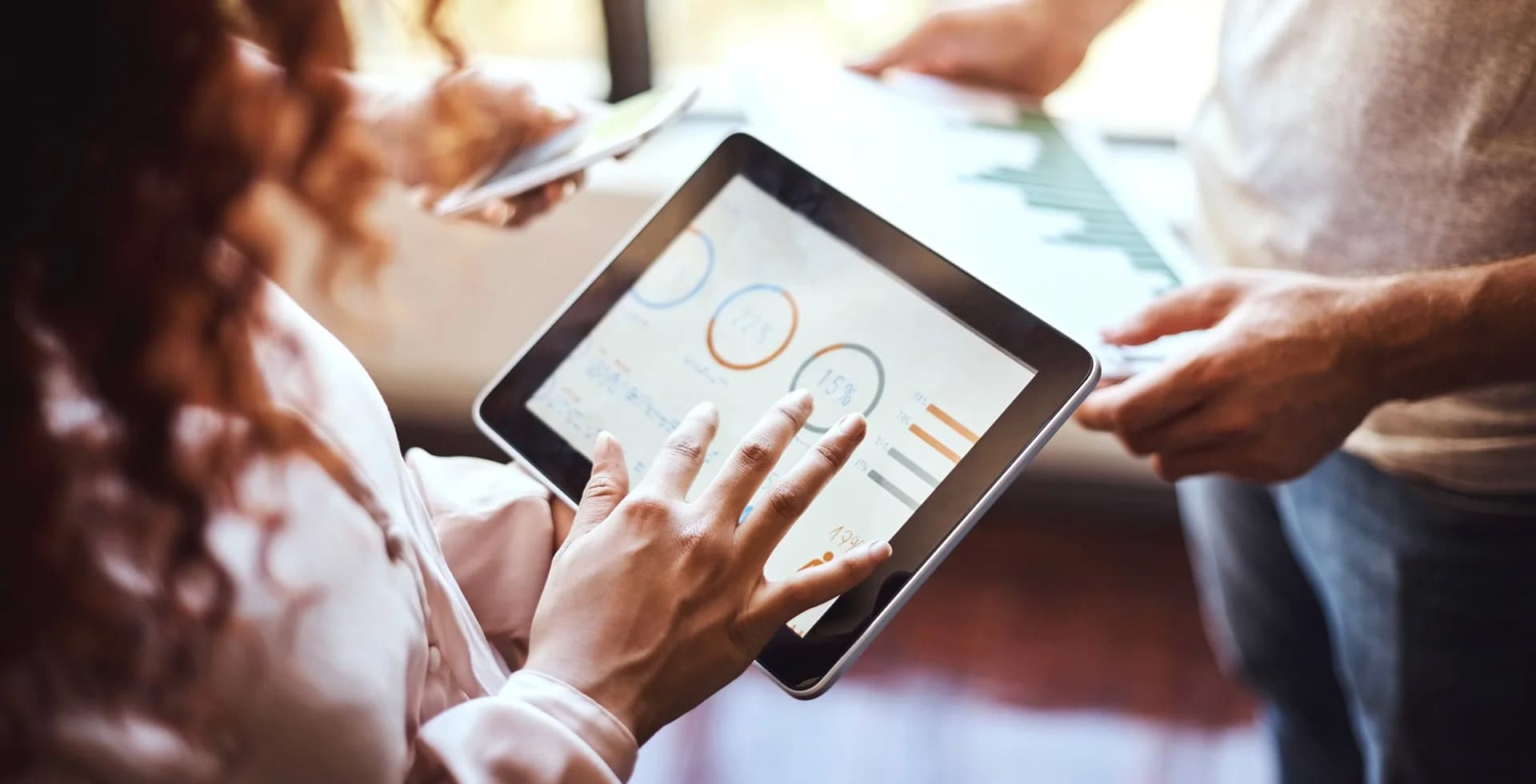 Une femme regarde des graphiques sur une tablette.