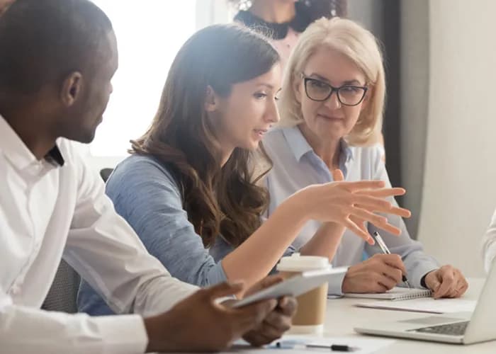 Trois partenaires commerciaux se rencontrent à un bureau.