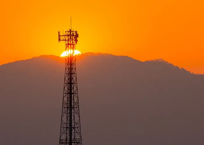 Tour de télécommunications devant le coucher du soleil.