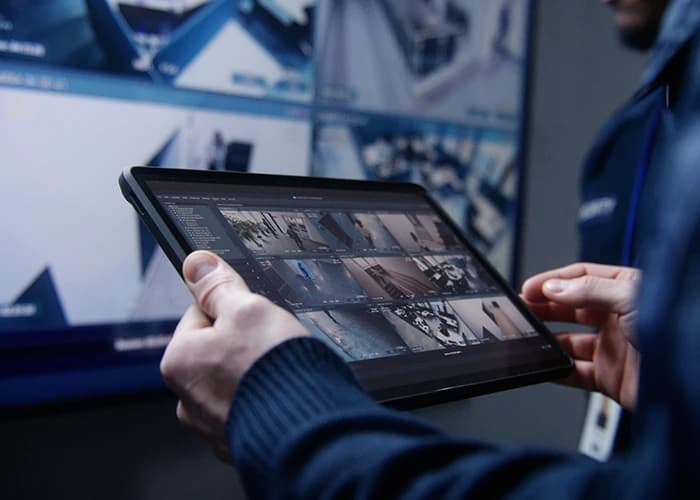 Person monitoring CCTV on a tablet