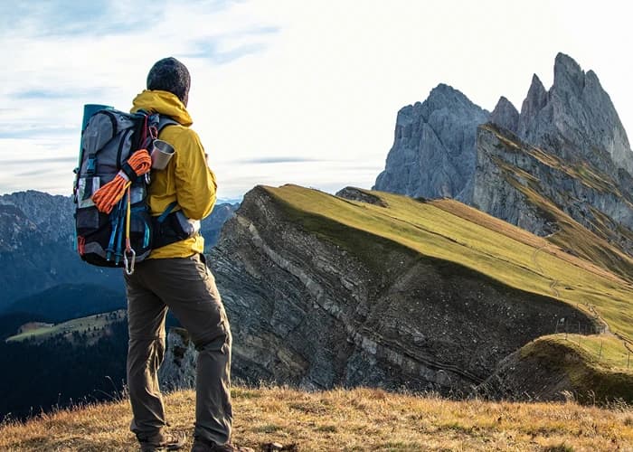 image d'un jeune homme faisant de la randonnée dans les montagnes au lever du soleil